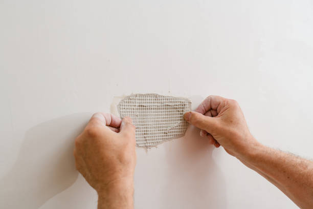 handyman-Orlando-Florida Drywall repair technician patching a hole in an Orlando home